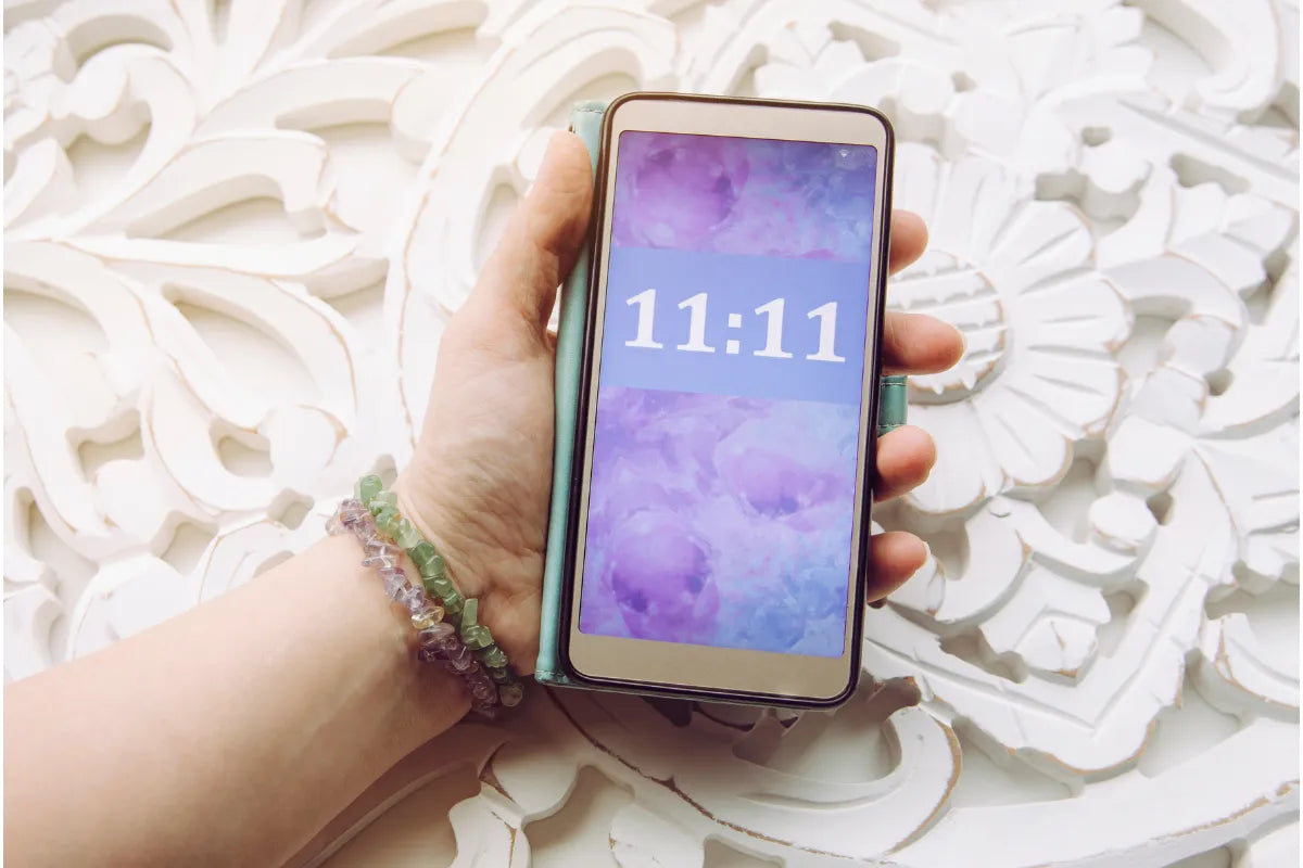 phone in hand with 11:11 angel number showing