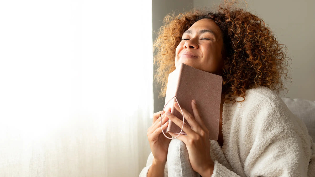 Young adult looking happy with her journal in hand