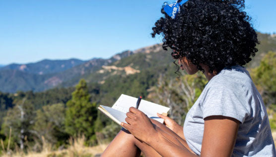 Woman writing in a journal during a mindfulness practice for stream of consciousness journaling and self-reflection.