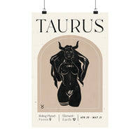 A minimalist Taurus astrology poster featuring a black illustration of a horned female figure on a beige arched background, with the word 'TAURUS' in large black letters at the top and additional text at the bottom, shown hanging against a white background.