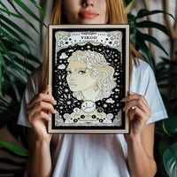 woman holding frame with Virgo cosmic zodiac portrait featuring a feminine figure surrounded by botanical details, stars, Virgo constellation, Mercury symbol, and Earth element
