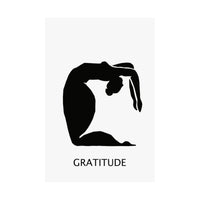A minimalist black graphic print featuring a silhouette of a person in a graceful arching pose, with the word 'GRATITUDE' printed below in a clean sans-serif font, set against a light gray rectangular card on a white background.