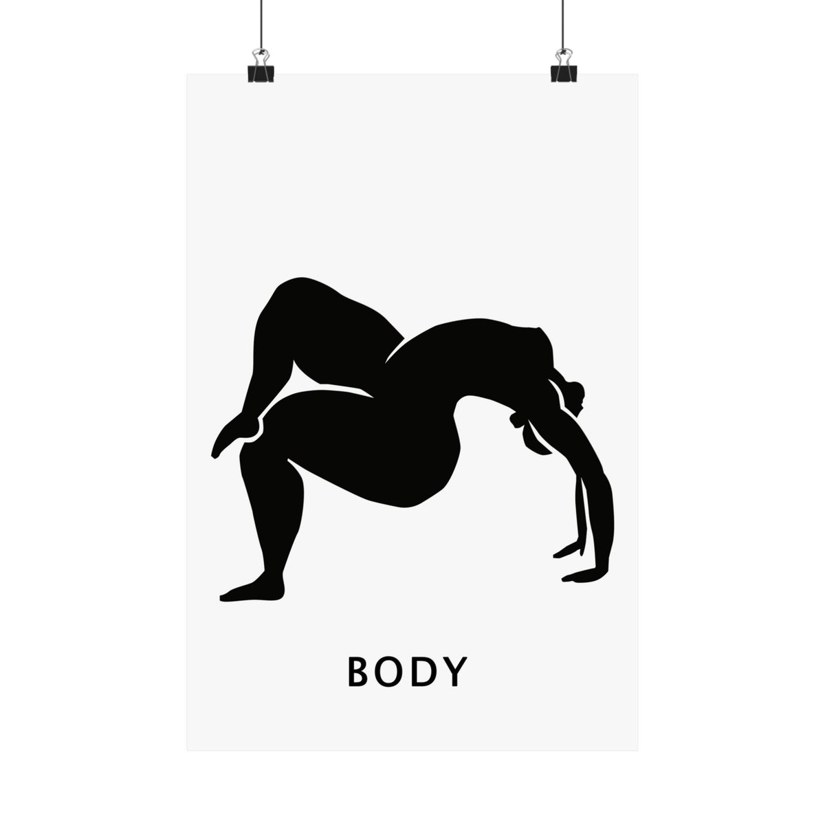 A minimalist black and white art print featuring a silhouette of a woman in a yoga pose with the word 'BODY' printed below in a sans-serif font. The poster is shown hanging from two black clips against a clean white background.