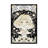 A vertical black-and-cream astrology poster featuring the Aquarius zodiac sign, with an illustrated woman's face, stars, moons, and astrological symbols. The poster is shown hanging against a white background with two black clips at the top.