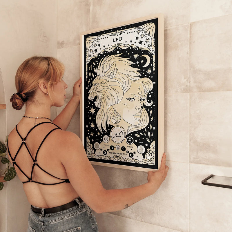 woman holding Leo cosmic zodiac portrait featuring a feminine figure and lion surrounded by stars, Leo constellation, Sun symbol, and Fire element