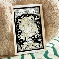 Aries cosmic zodiac portrait featuring a feminine figure with Ram horns surrounded by stars, Aries constellation, Mars symbol, and Fire element