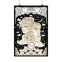 A vertical tarot-style poster hanging from two black clips against a light gray wall. The artwork is predominantly black and warm cream/beige, featuring two illustrated women in profile, stars, clouds, a crescent moon, and astrological symbols.