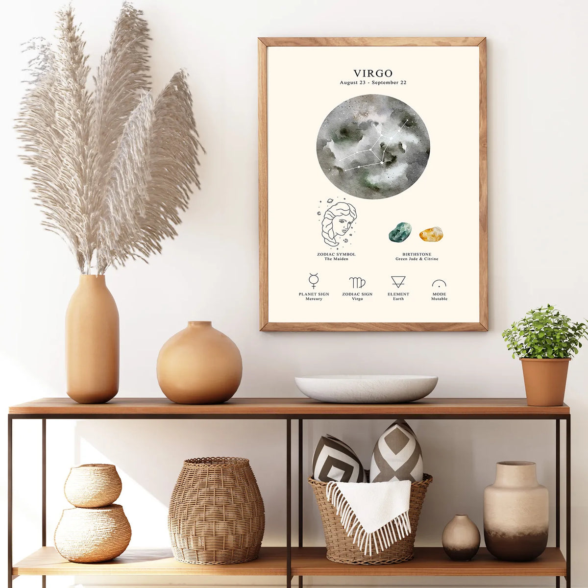 A framed art print featuring a watercolor-style Virgo moon chart and crystal guide, displayed on a white wall above a wooden console shelf with decorative vases, baskets, and a small plant.