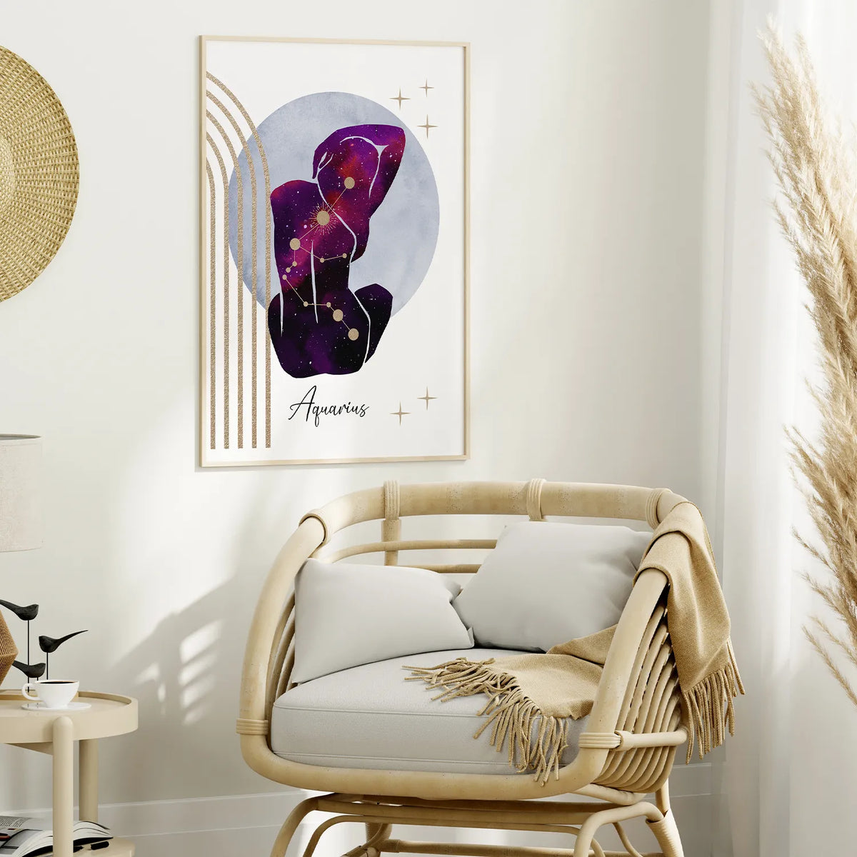 A framed abstract art print featuring the Aquarius zodiac sign in purple and black tones with gold accents, displayed on a white wall above a rattan armchair in a styled living room.