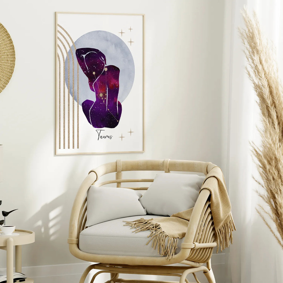 A framed abstract wall art print hangs above a rattan lounge chair in a styled interior. The artwork features a purple and violet abstract figure with gold accents inside a pale blue oval, with the word 'Yours' below.