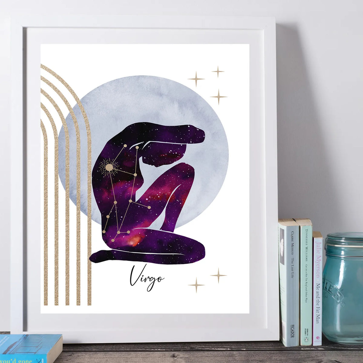 A framed art print featuring a stylized seated figure filled with a purple and pink galaxy pattern, set against a large pale blue circle and gold arches on a white background. The word 'Virgo' appears below in black script.