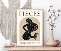 A framed Pisces zodiac art print displayed on a wooden shelf in a styled home decor setting, featuring a black line art illustration of a mermaid on a beige background with cream text.