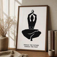 A minimalist black-and-white wall art print featuring a seated yoga figure with the text 'INHALE THE FUTURE EXHALE THE PAST'  brown frame