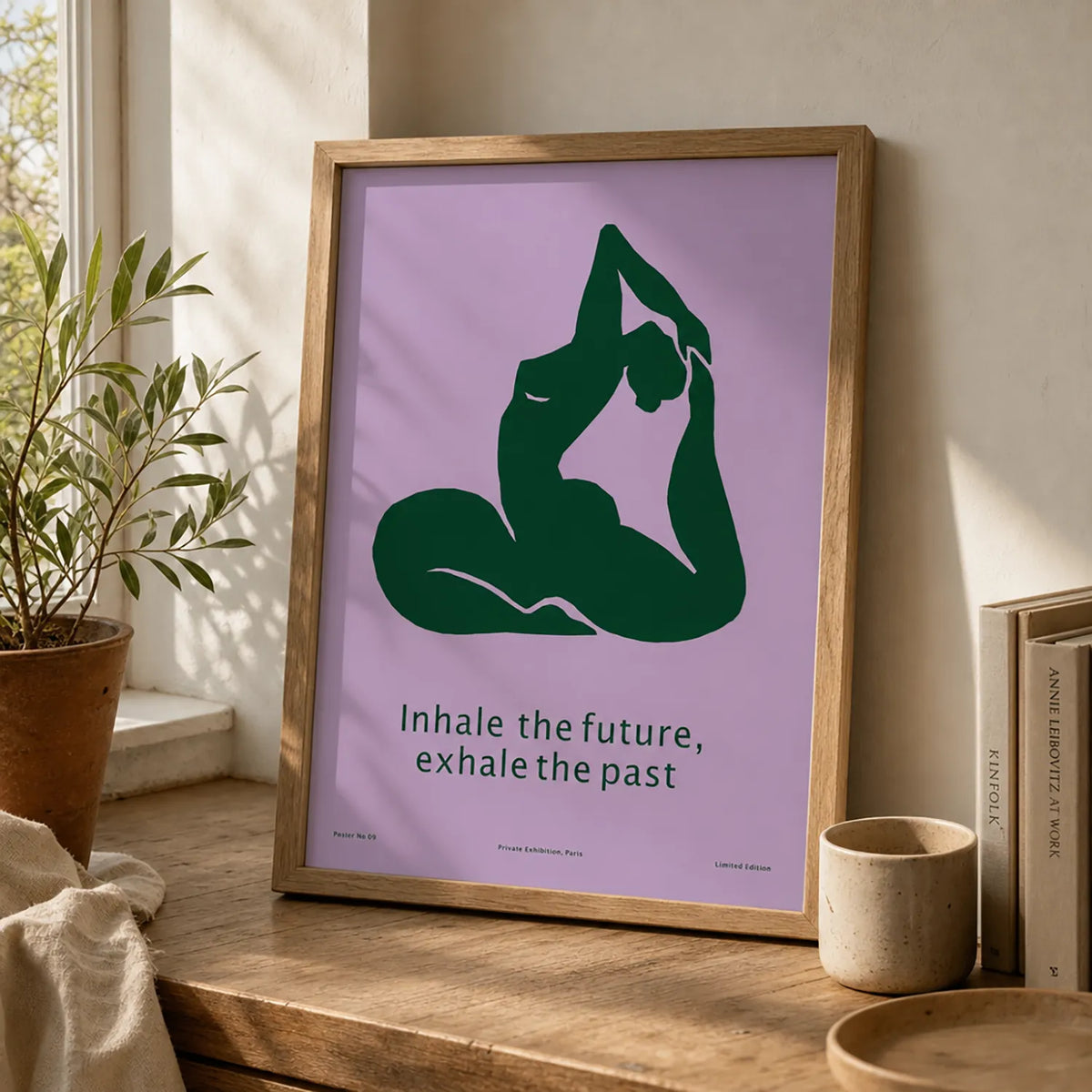 Framed minimalist yoga art print featuring a deep-green yoga silhouette and the words “Inhale the future, exhale the past” on a lavender background.