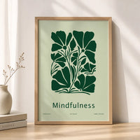 Minimalist mindfulness art print featuring bold dark-green botanical flowers and the word “Mindfulness” on a pale-green background, displayed in a brown frame.