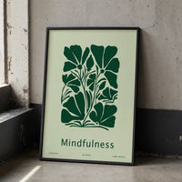 Minimalist mindfulness art print featuring bold dark-green botanical flowers and the word “Mindfulness” on a pale-green background, displayed in a black frame.