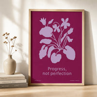 Framed botanical art print featuring lavender flowers on a rich berry-pink background with the words “Progress, not perfection.”