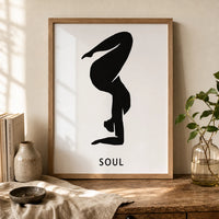 A minimalist black graphic of a person in a yoga or handstand pose on a white rectangular card, with the word 'SOUL' in brown frame