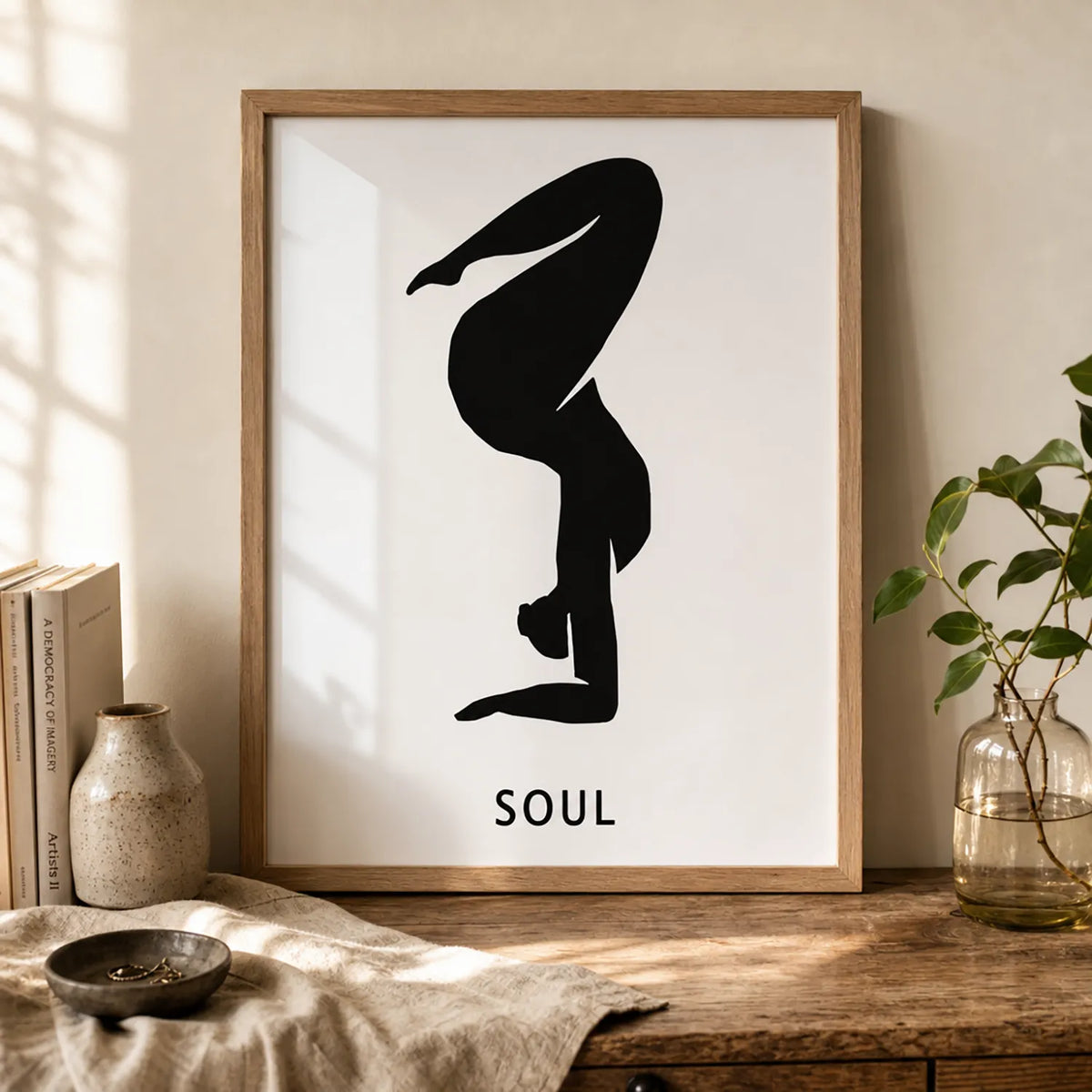 A minimalist black graphic of a person in a yoga or handstand pose on a white rectangular card, with the word 'SOUL' in brown frame