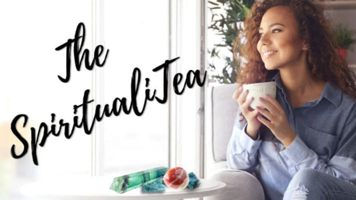 Woman smiling with tea, crystals on table, The SpiritualiTea text, cozy indoor setting