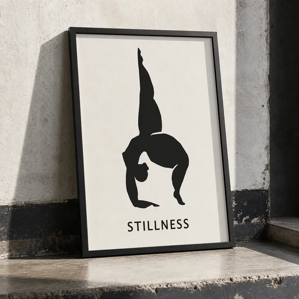 A minimalist wall art print featuring a black silhouette of a person in a handstand pose on a white background, with the word 'STILLNESS' in black frame
