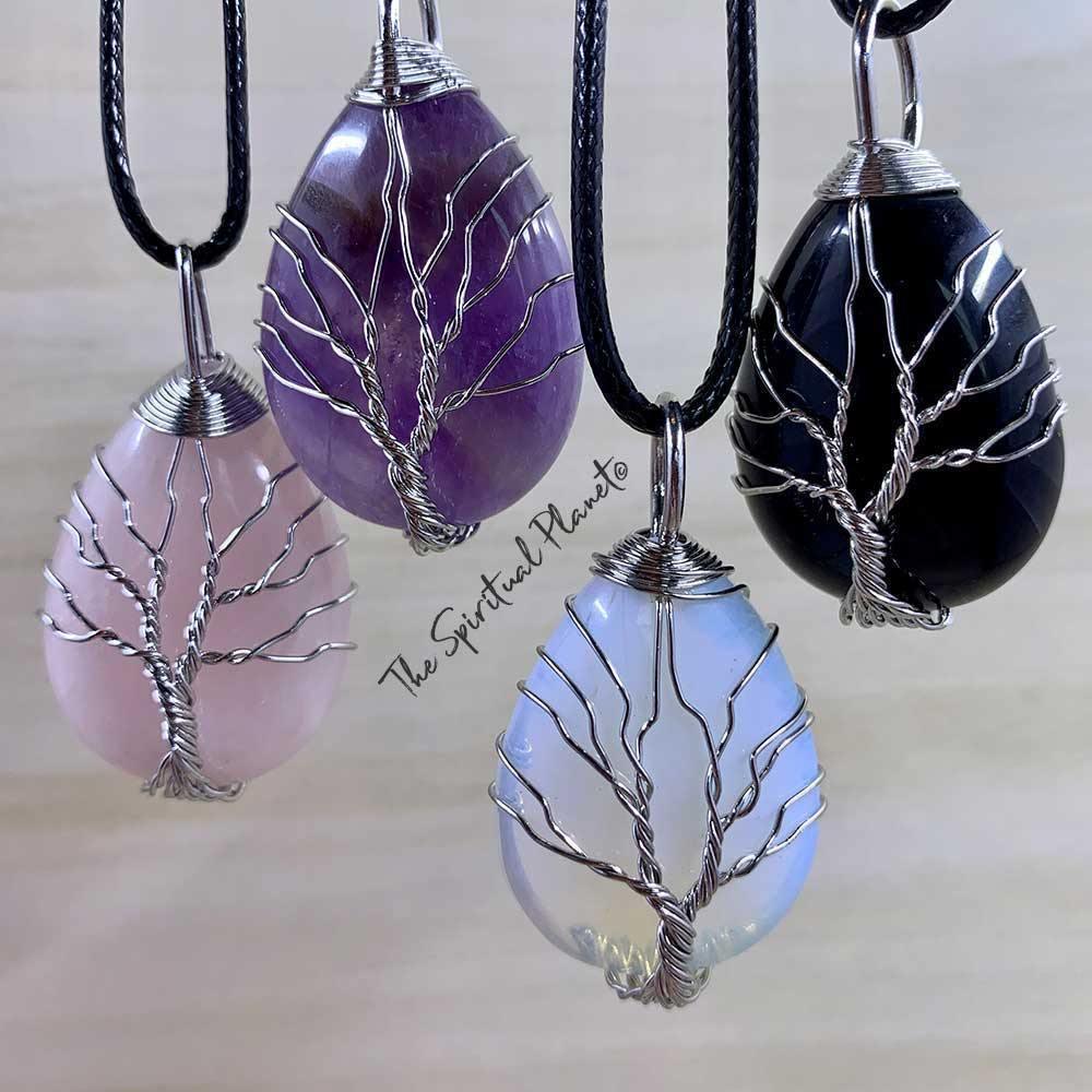 Crystal necklaces with tree of life wire wrapping, featuring amethyst, rose quartz, black, and opalite pendants.